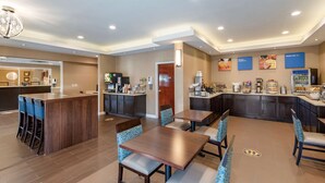 A modern hotel lobby with a central bar area, seating arrangements, and a reception desk.