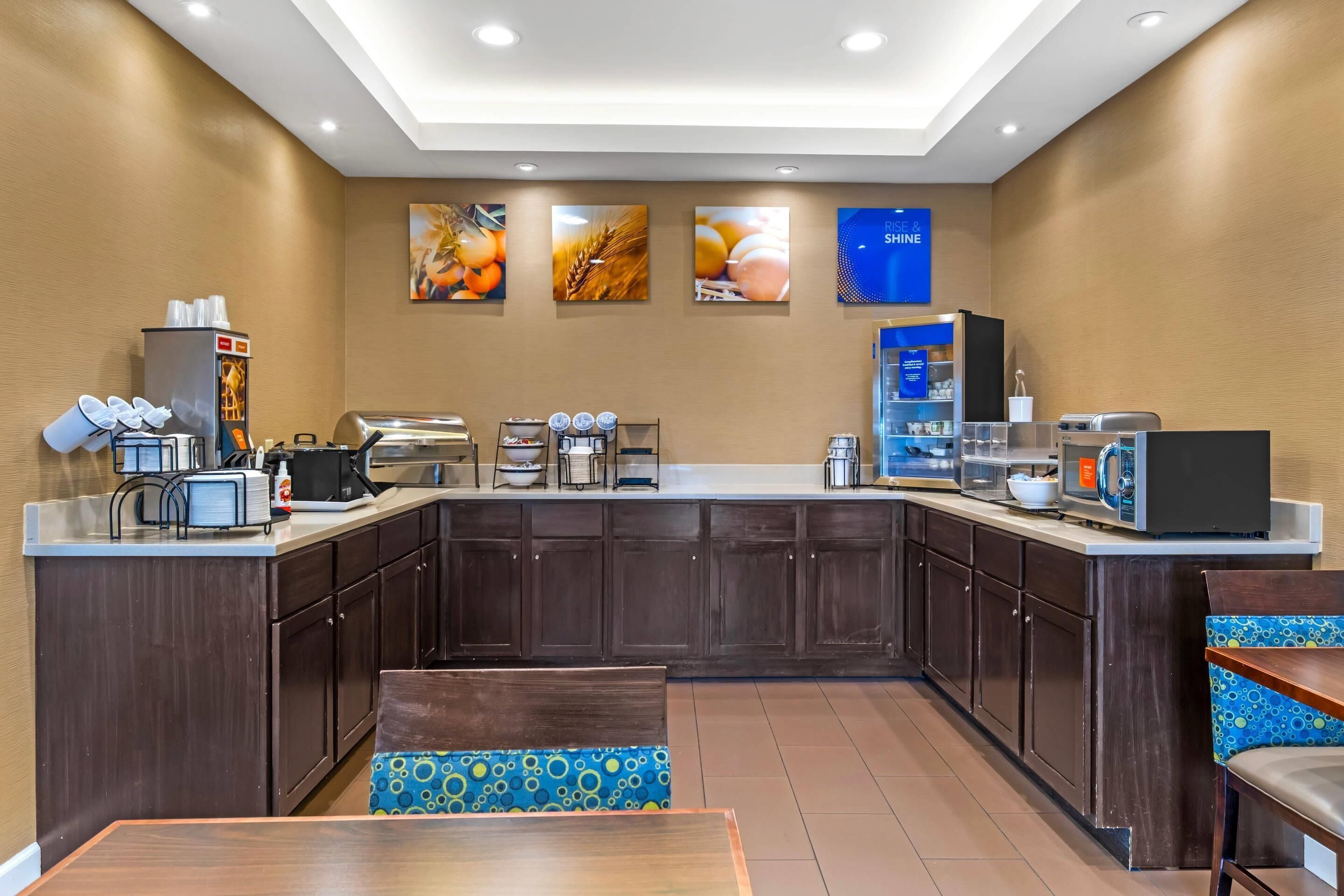 Una cocina moderna con armarios de madera oscura, una isla central y una zona de estar con un banco estampado.