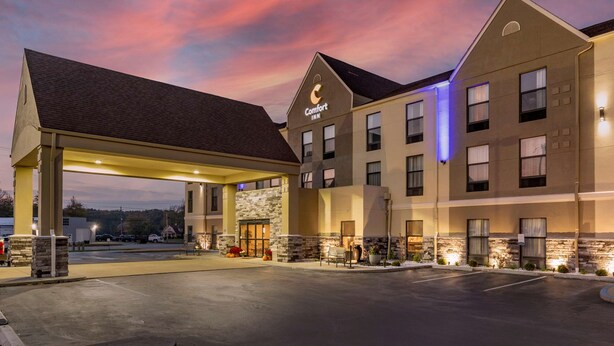 A Comfort Inn hotel with a gas station attached, featuring a stone facade and multiple windows.
