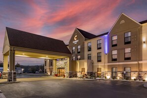 A Comfort Inn hotel with a gas station attached, featuring a stone facade and multiple windows.