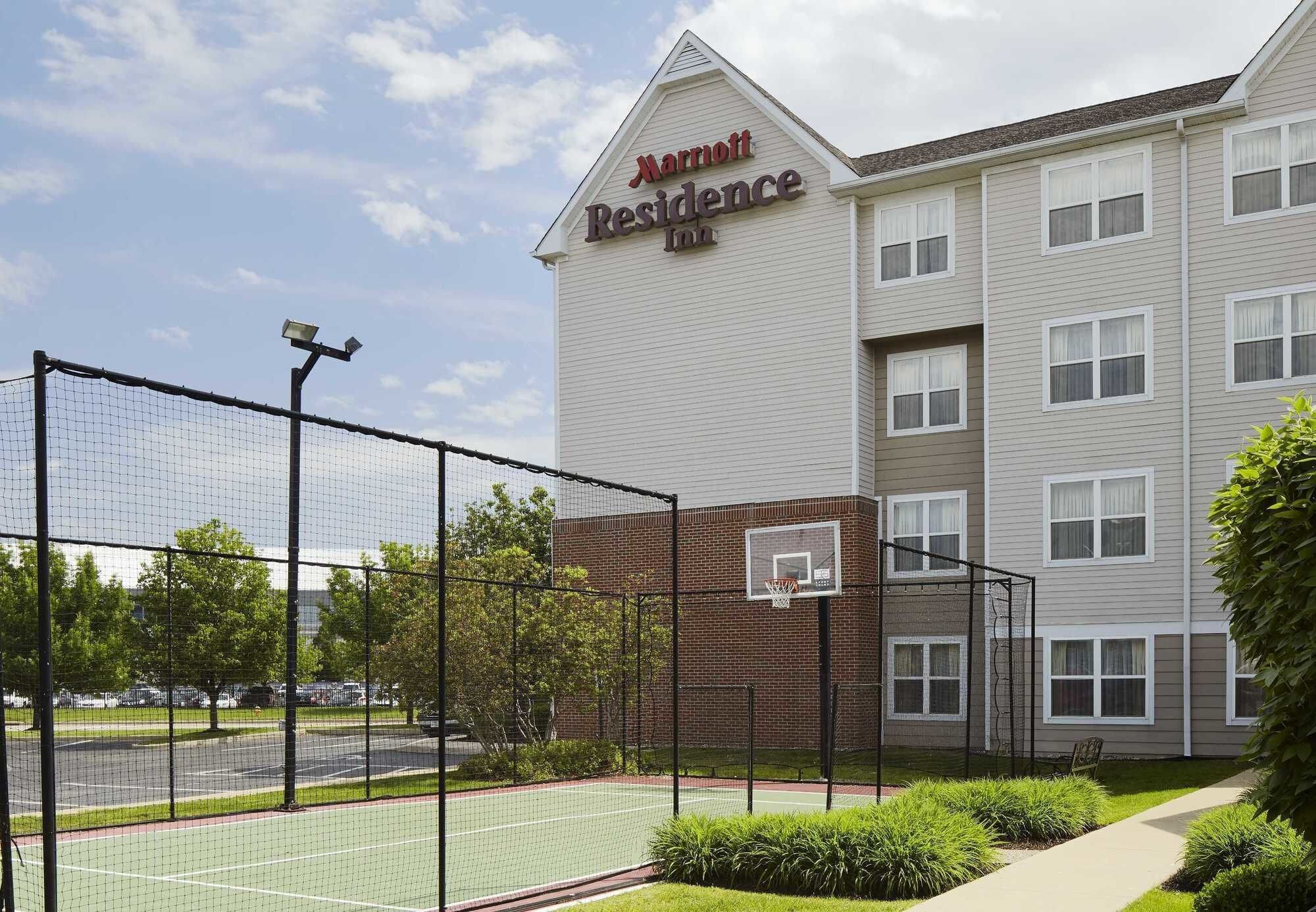 A Marriott Residence Inn with a basketball court in front.