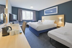 A hotel room with two beds, a desk with a television, a kettle, and mugs. - Travelodge Aberdeen Bucksburn (Aberdeen)