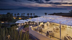 A rooftop terrace with tables and chairs, overlooking a body of water and mountains. - CDSHotels Terrasini - Città del Mare (Terrasini)