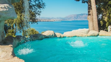 Een seizoensgebonden buitenzwembad, parasols voor strand/zwembad
