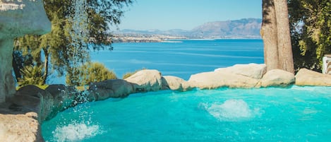 Una piscina al aire libre de temporada, sombrillas