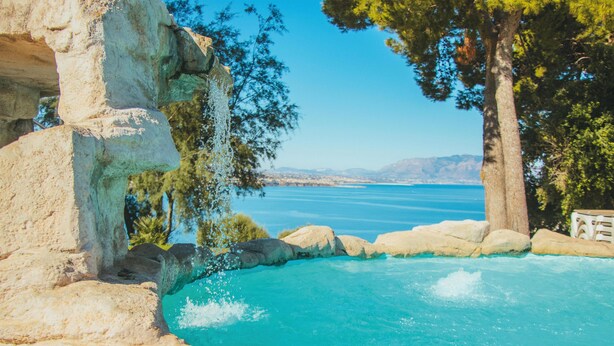 A clear blue pool surrounded by rocky formations and trees. - CDSHotels Terrasini - Città del Mare (Terrasini)