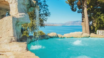 Una piscina al aire libre de temporada, sombrillas, tumbonas