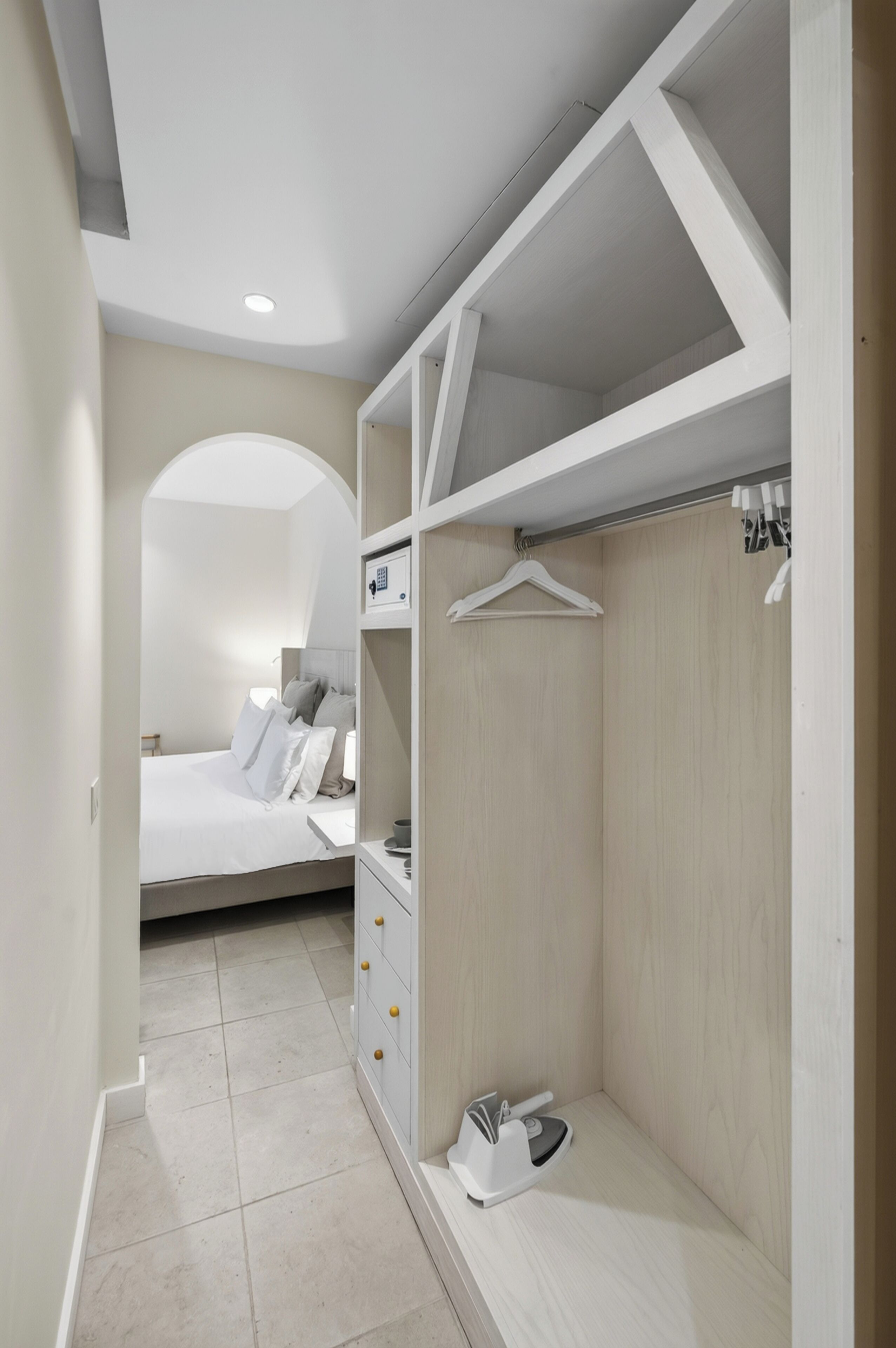 A bedroom with a bed, a dresser, and a walk-in closet with hanging space.