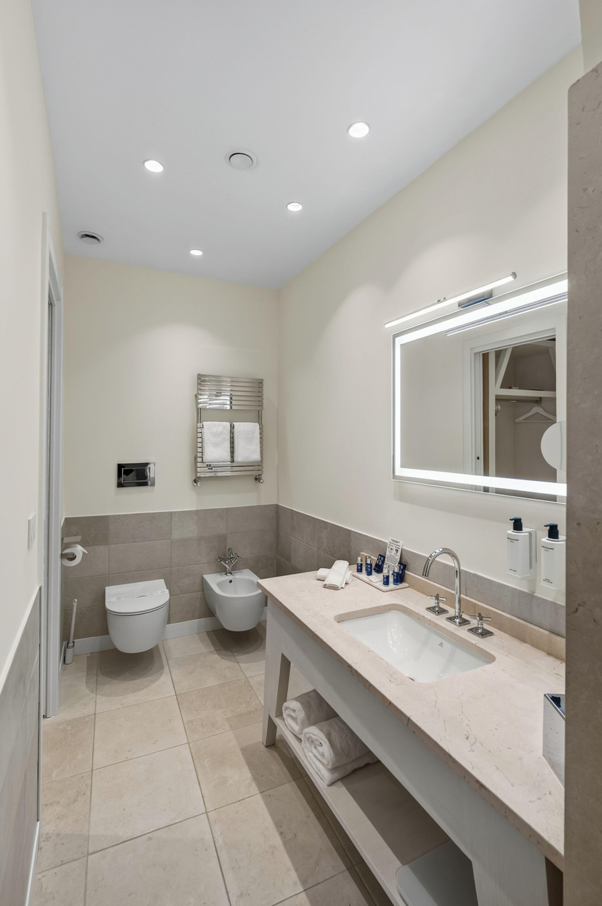 Une salle de bain moderne avec un double lavabo, un bidet et des toilettes.