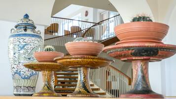 A staircase with a railing, a large decorative vase, and several terracotta pots.
