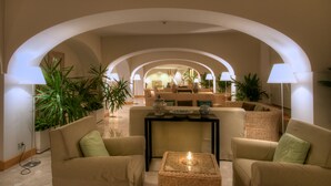 A spacious lounge area with high arched ceilings, comfortable seating, and ambient lighting. - Grand Hotel Aminta  (Sorrento)
