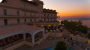 Enjoy panoramic views of the water from our rooftop terrace, featuring multiple levels with seating areas and lush greenery.