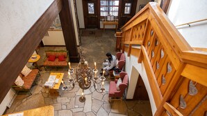 A spacious lobby with a stone floor, wooden staircase, and comfortable seating areas. - Alpenhof (Teton Village)