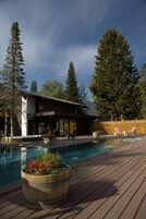 Una piscina al aire libre, sillones reclinables de piscina