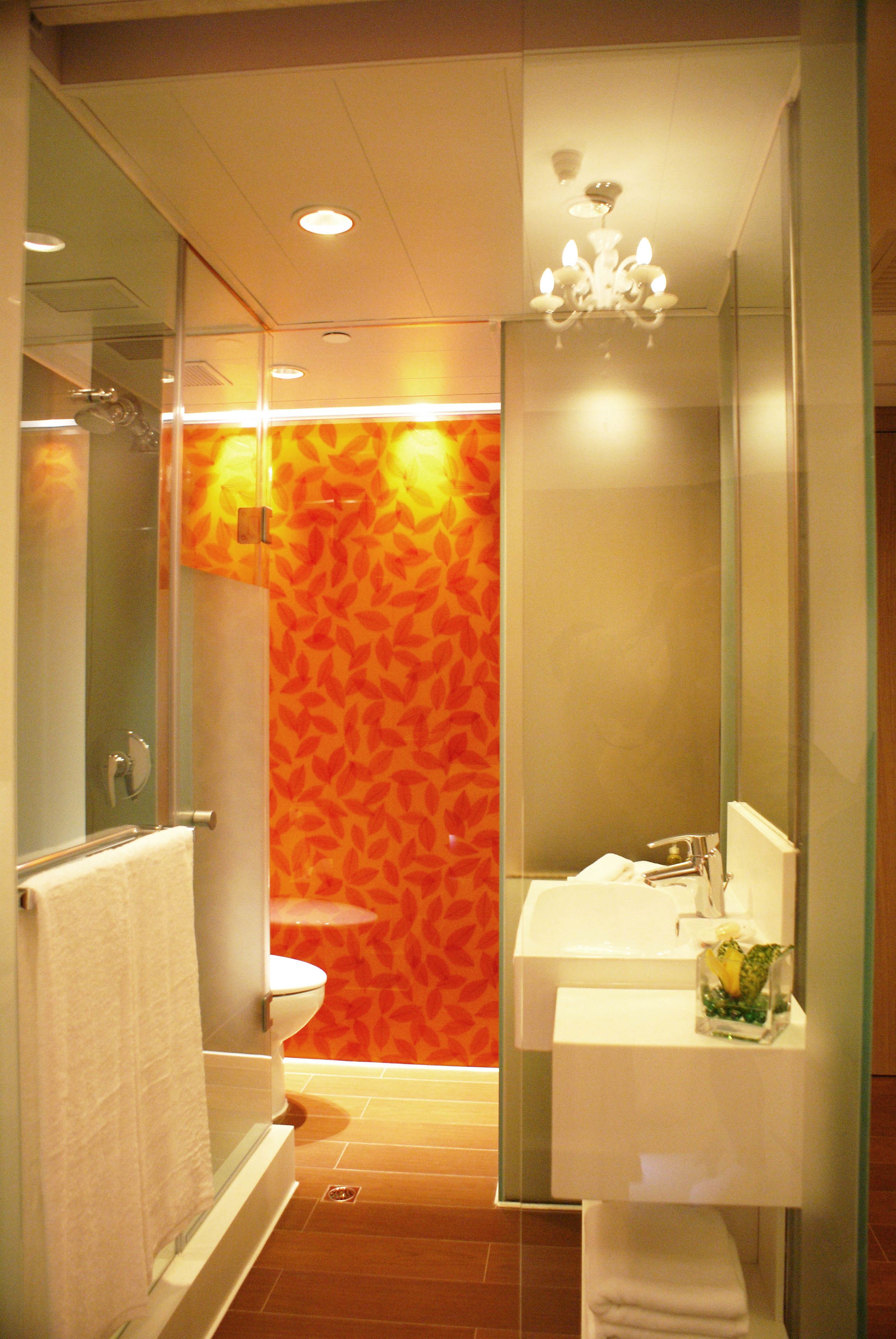 A bathroom with a glass shower enclosure, a white sink, and a mirror.