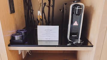 Un carrito de desayuno con una cafetera, un cartel y una bandeja con tazas, cucharas y una servilleta.