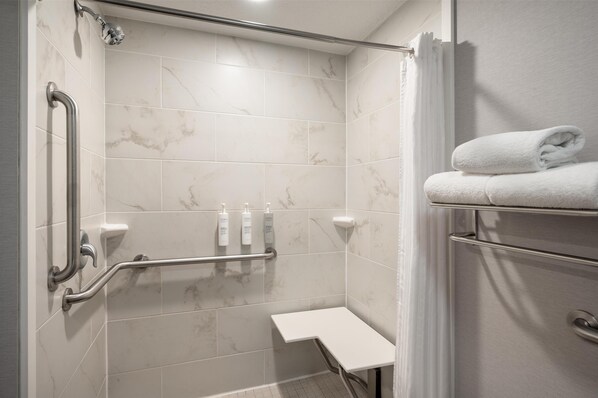 A shower with a grab bar, a white towel rack, and a shelf with toiletries. - Homewood Suites by Hilton Columbus/Polaris, OH (Columbus)