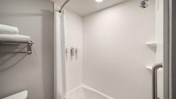 A modern bathroom with a shower, a toilet, and a towel rack.