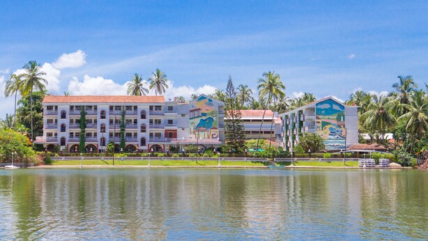 A hotel with multiple floors, balconies, and a mural on one side. - Resorte Marinha Dourada (Arpora)