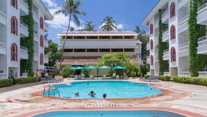 A swimming pool with a 'NO DIVING' sign, surrounded by a building with balconies and a tropical setting. - Resorte Marinha Dourada (Arpora)