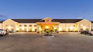 A Comfort Suites hotel with a large parking lot and a well-lit entrance. - Comfort Suites Idabel (Idabel)