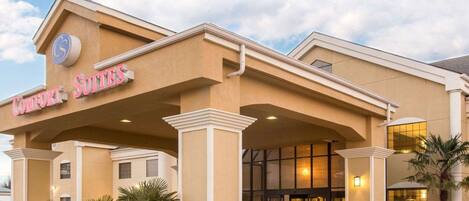 A hotel entrance with a sign reading "Comfort Suites."