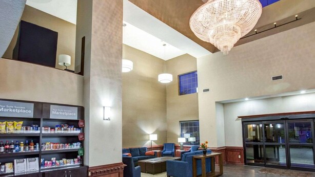 A spacious lobby with a chandelier, seating area, and a kitchenette with snacks. - Comfort Suites Idabel (Idabel)