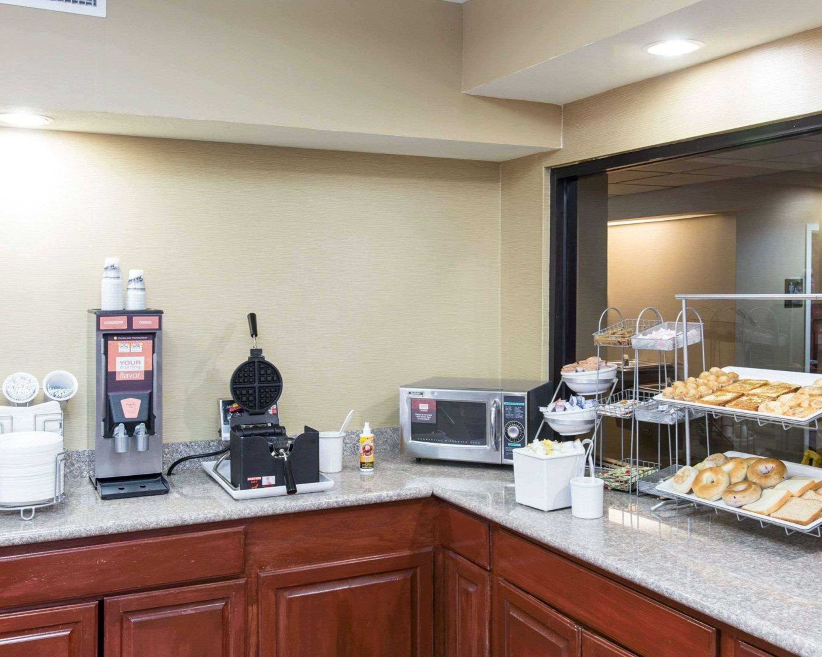 Una estación para el desayuno con máquinas para hacer gofres, una cafetera y un microondas.