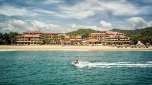 A beachfront hotel with multiple buildings, a sandy beach, and palm trees. - Barceló Huatulco - All Inclusive (Santa María Huatulco)