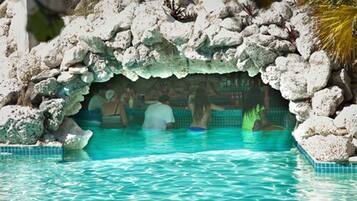 A pool with clear water, surrounded by rocks and a tiled edge.