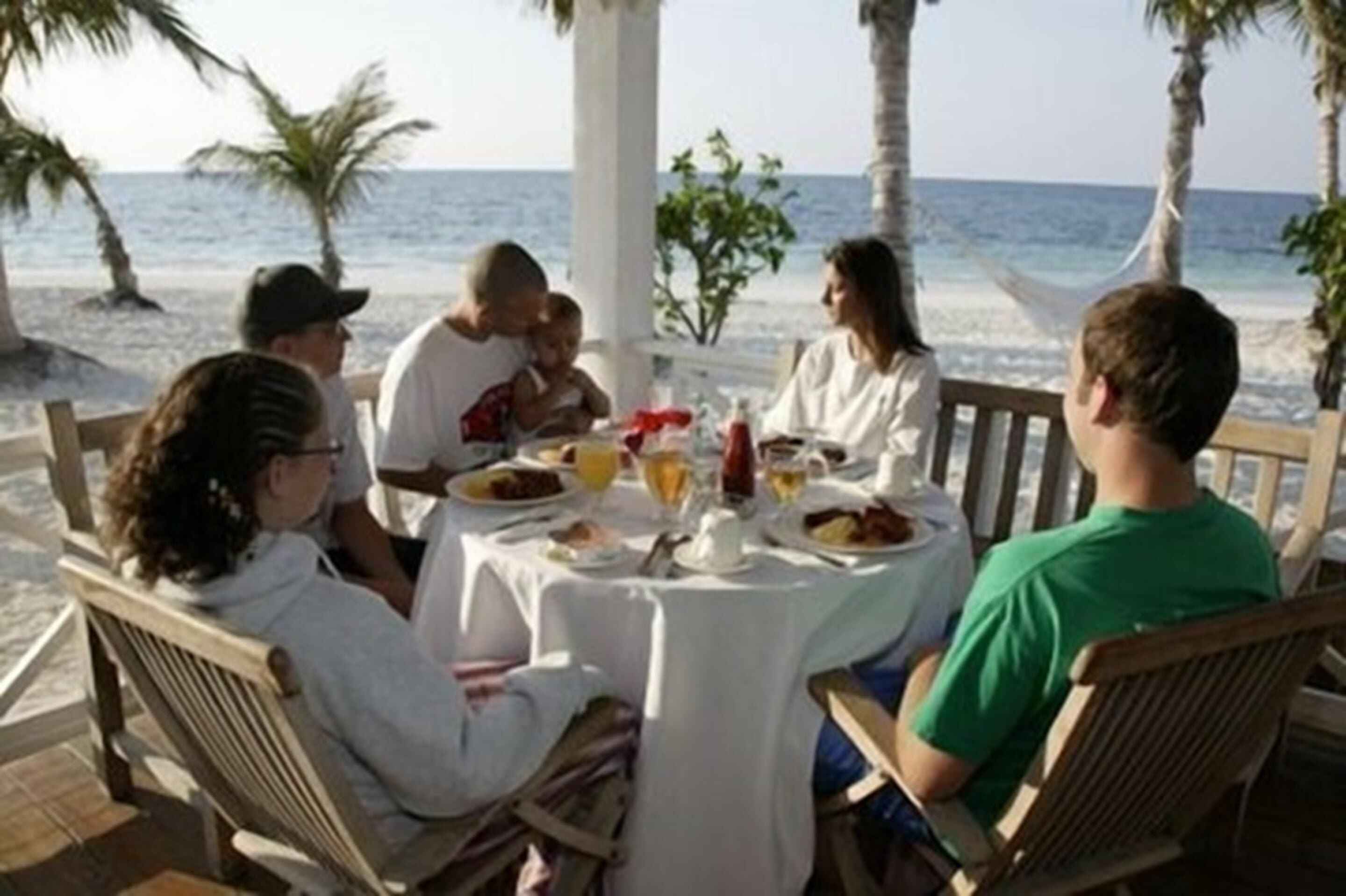 A group of people dining at a table with a view of the ocean.