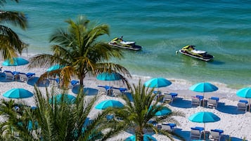 Relax on the beach with ocean views, lounge chairs, and umbrellas for shade.