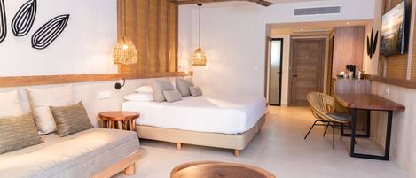 Un dormitorio moderno con una cama, cabecera de madera, mesitas de noche, una mesa de centro redonda de madera y un comedor con mesa y sillas.
