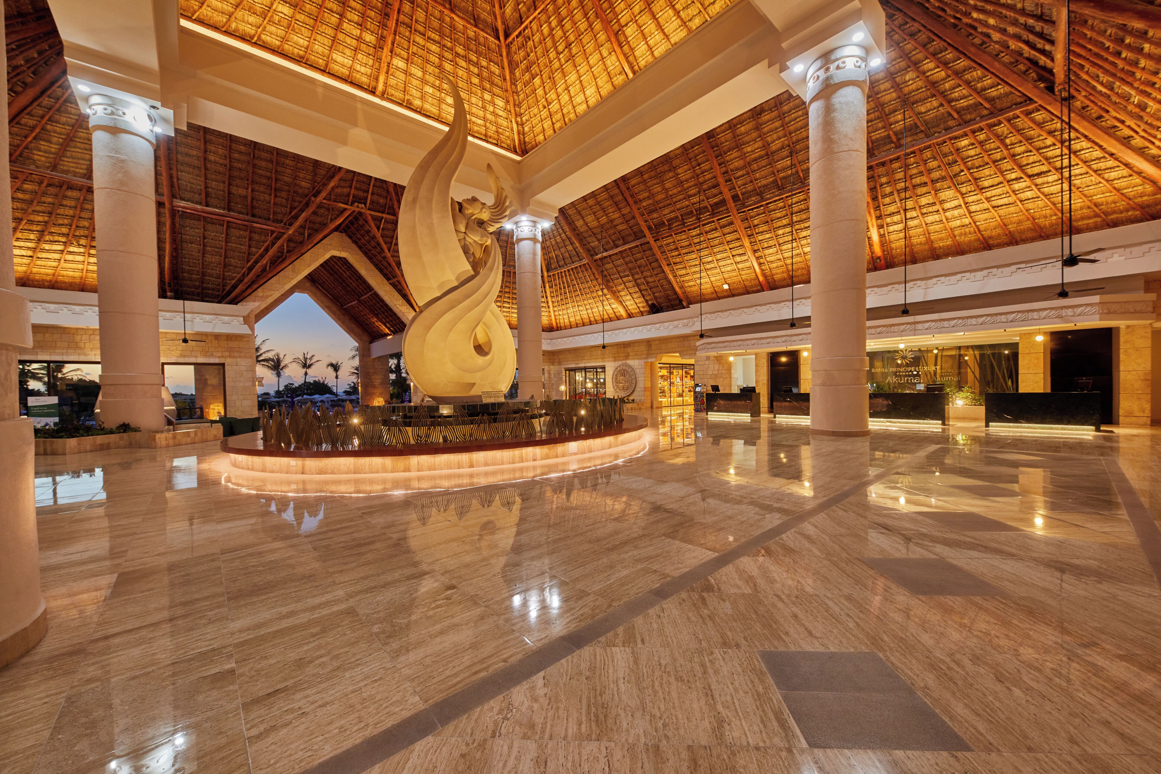 A spacious lobby with a high ceiling, large columns, and a central decorative feature.