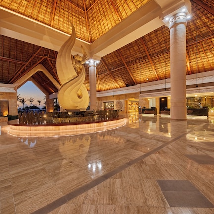A spacious lobby with a high ceiling, large columns, and a central decorative feature.