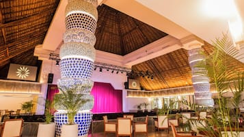 Un vestíbulo con techos altos, columnas decoradas y zonas de estar.
