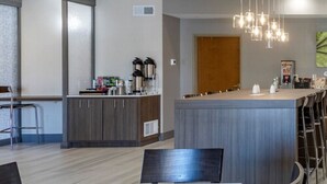 A modern kitchen with a central island, bar stools, and pendant lighting. - Sleep Inn & Suites Lebanon - Nashville Area (Lebanon)