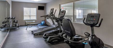 A gym with treadmills, elliptical machines, and weight machines.