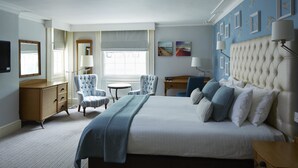 A bedroom with a large bed, two armchairs, a desk, and a window with blinds. - The Old Ship Hotel (Brighton)