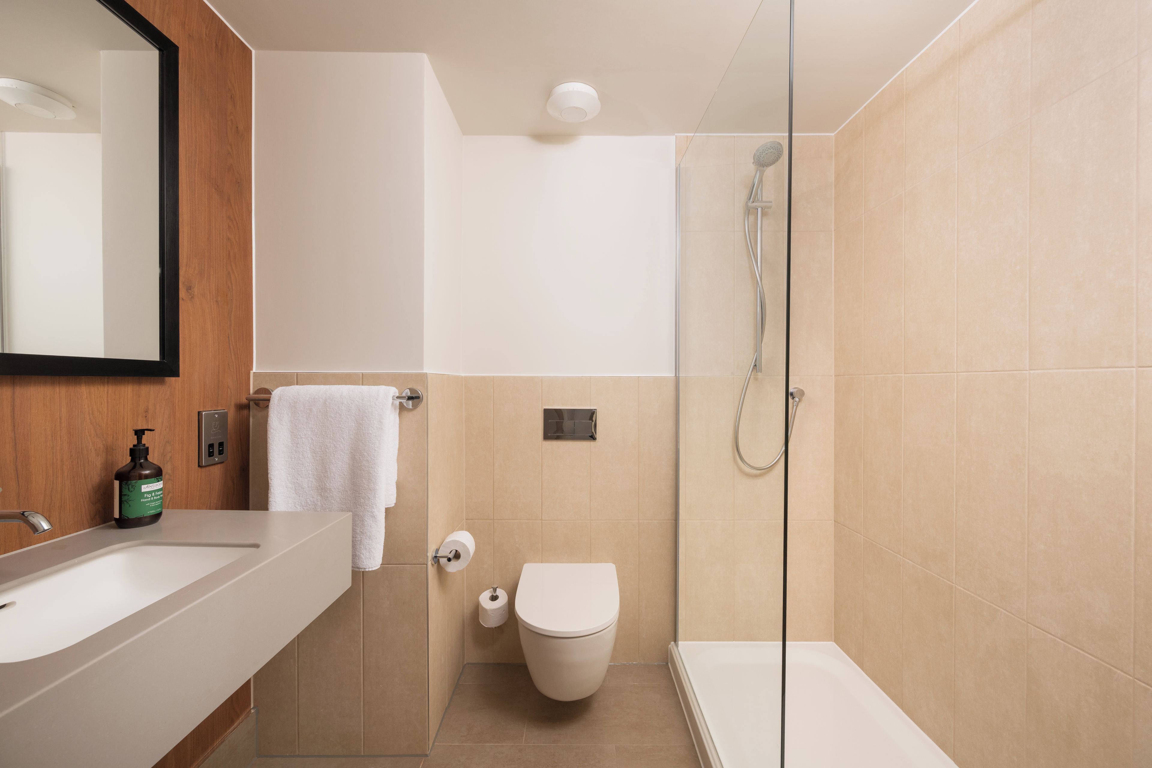 A modern bathroom with a shower, toilet, and sink.