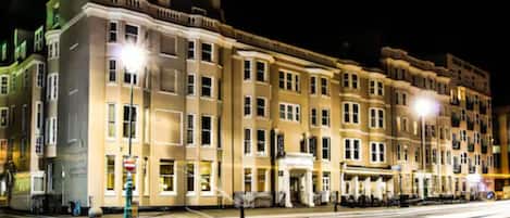 A multi-story hotel with a classic architectural style, featuring a central entrance and uniform window design.