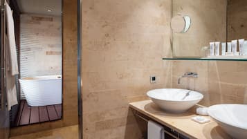 A modern bathroom with two white sinks, a glass shower enclosure, and a large mirror above the sink.