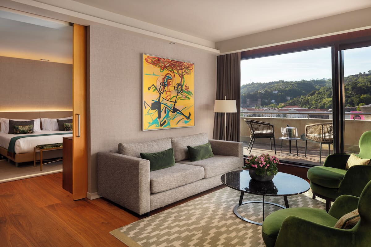 Una habitación de hotel con sofá, mesa de centro y un cuadro en la pared.