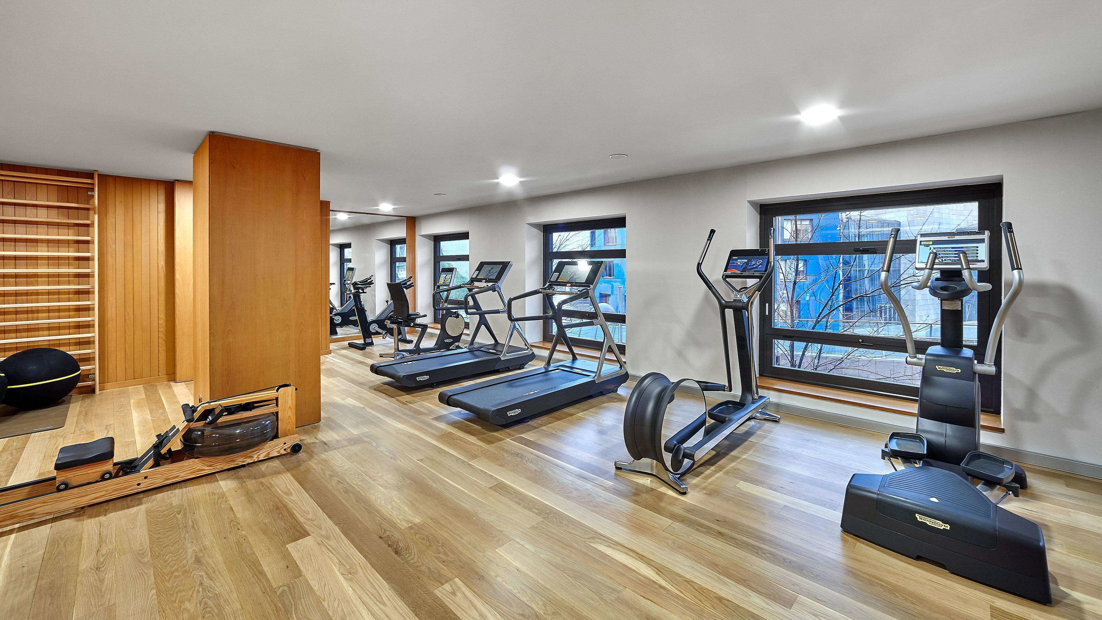 A gym with treadmills, elliptical machines, and a rowing machine.