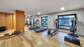A gym with treadmills, elliptical machines, and a rowing machine.
