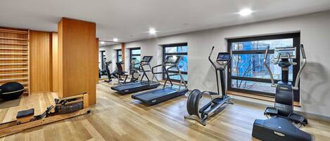A gym with treadmills, elliptical machines, and a rowing machine.