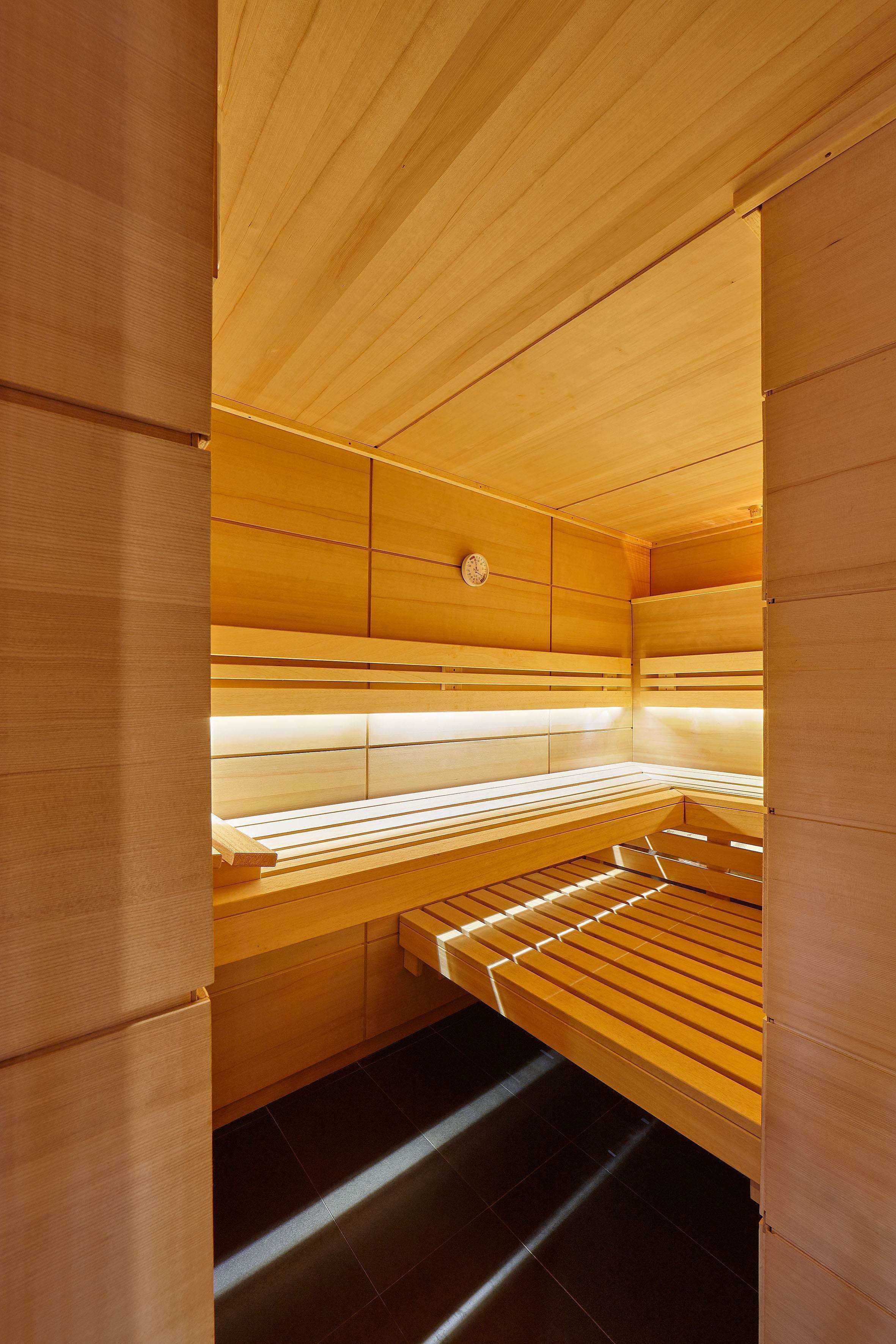 A sauna with wooden benches and a sloped ceiling.