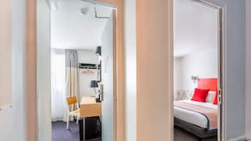 Une chambre d’hôtel comprenant un lit, un bureau, une chaise et une armoire.