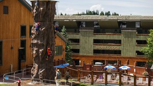 A climbing wall adjacent to a building with a sign reading "SIOUX LODGE". - Grand Targhee Resort (Alta)