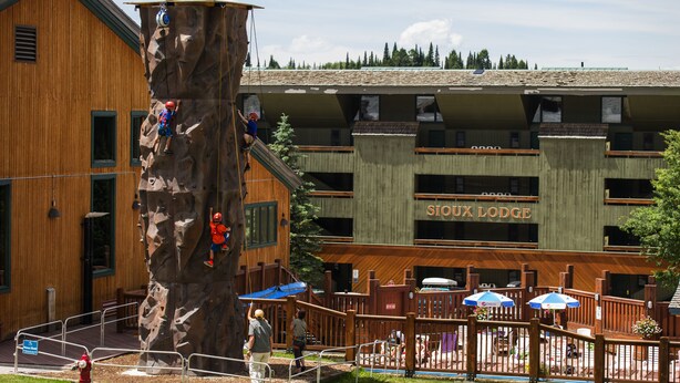 Un mur d’escalade situé à côté d’un bâtiment sur lequel on peut lire l’inscription : « SIOUX LODGE ».